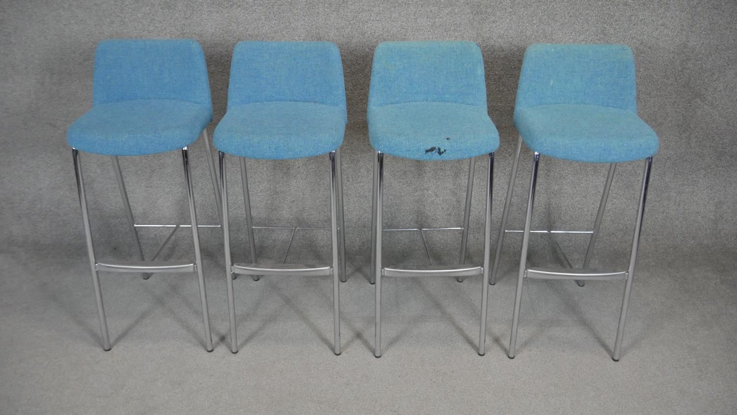 A set of four contemporary upholstered and metal framed high stools.