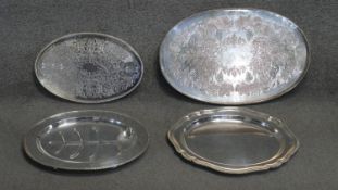 Four oval silver plated serving trays, two with engraved decoration, one with a vine and grape