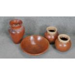 A collection of four terracotta effect ceramic pieces. Including a large fruit bowl and two urn