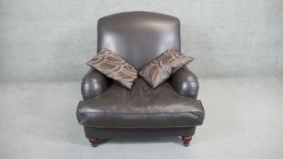 A contemporary Howard style armchair by Laura Ashley in tobacco leather upholstery on turned