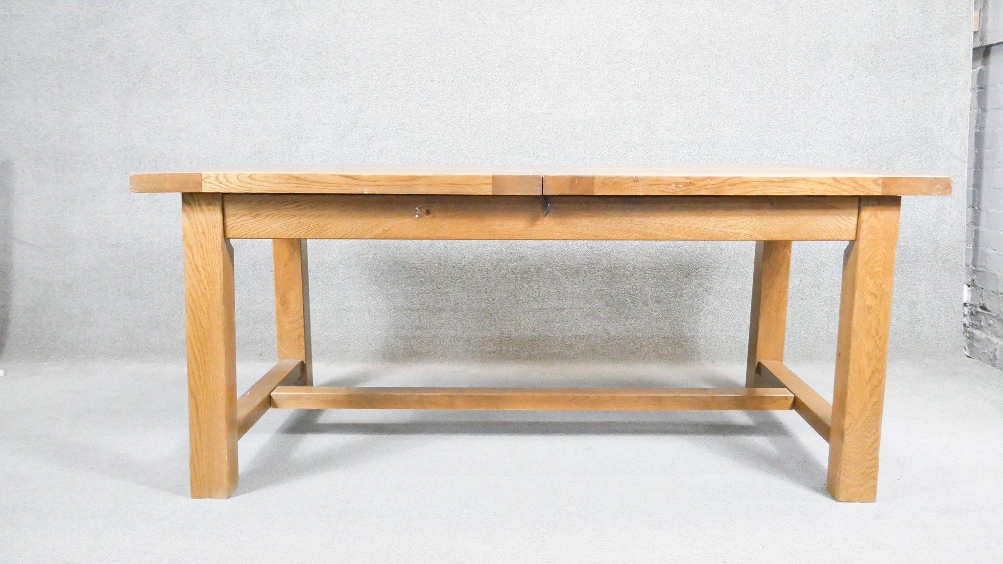 A contemporary John Lewis light oak planked top extending dining table on stretchered square