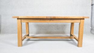 A contemporary John Lewis light oak planked top extending dining table on stretchered square