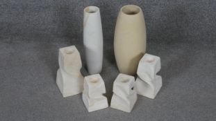 A collection of carved sandstone items. Including two vases and two pairs of twisted design candle