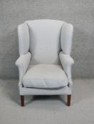 A Georgian style wingback armchair in pale blue upholstery on square supports.