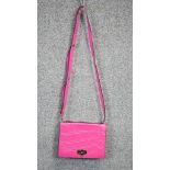 A neon pink Diane Von Furstenberg embossed leather crossbody bag. Brass Hardware and gilded name.