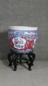 A contemporary Chinese hand painted porcelain goldfish bowl on ebonised stand. Decorated with