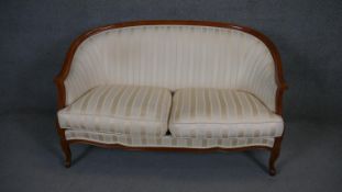 A Louis XV style two seater canape in striped upholstery on carved cabriole supports.