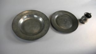 Two 18th century pewter plates and a pewter gill measure. Both plates have impressed stamps to the