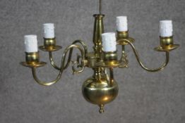 A Dutch style vintage five branch brass chandelier with scrolling design.