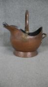 A Victorian beaten copper helmet shaped coal scuttle and shovel with brass carrying handle. H.40 W.