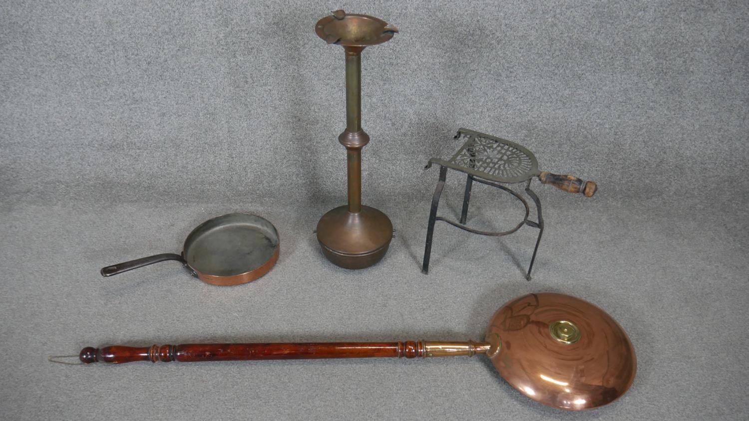 A large Victorian oak and copper bed warmer along with a brass floor standing weighted ash tray, a