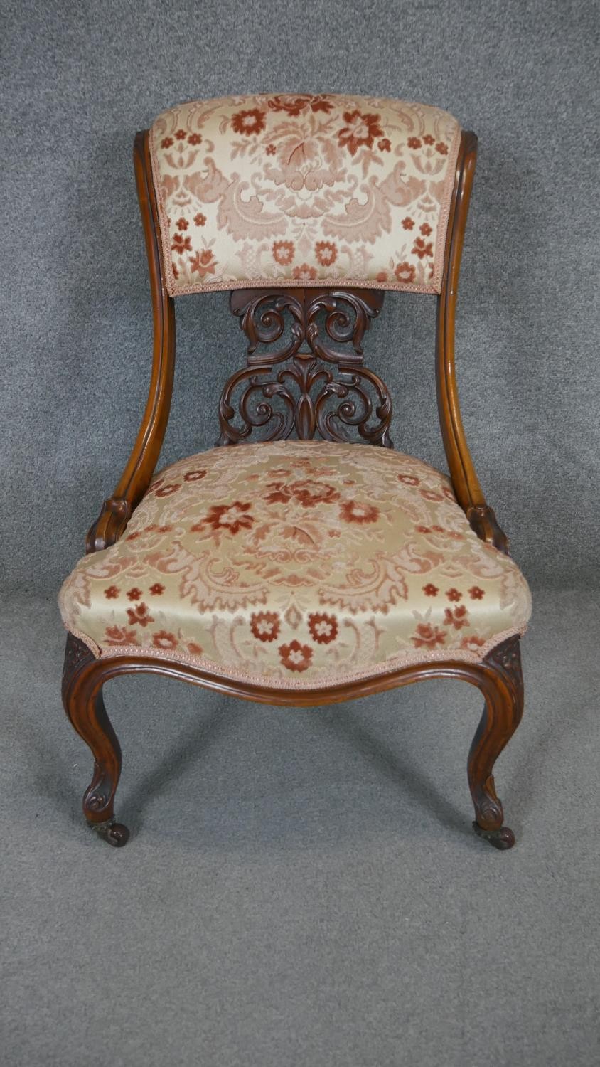 A Victorian carved walnut nursing chair on cabriole supports.