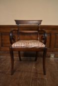 A Regency mahogany bar back armchair with scroll arms and drop in upholstered seat on sabre