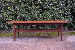 A vintage teak coffee table fitted with under tier on shaped tapering supports. H.16 W.113 D.38cm