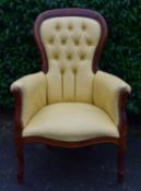A 19th century style mahogany framed armchair in deep buttoned faux leather upholstery. H.102 W.70