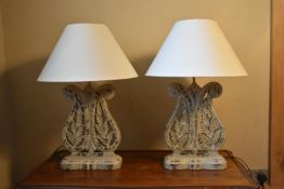 A pair of contemporary distressed, painted, pierced and carved table lamps with foliate