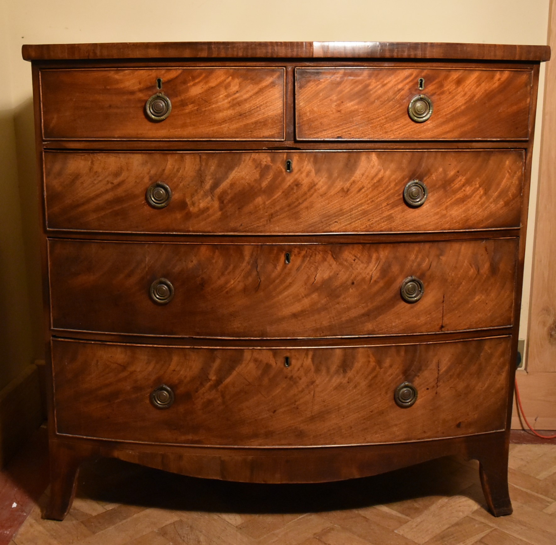 A Georgian flame mahogany bow fronted chest on swept bracket supports., H.107 W.109 D.52cm