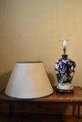 A contamporary baluster form table lamp with floral decoration and cream shade. H.60 W.22cm (not