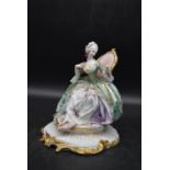 A hand painted Victorian lady figurine, wearing floral gown dress and seated on throne chair, with