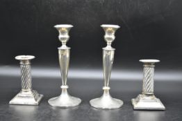 A pair of silver candlesticks with a twisted style to the column and beading decoration to the base,