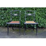 A pair of Regency ebonised dining chairs with rope twist backs above caned seats on sabre