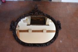A large 19th century carved and stained pitch pine wall mirror with ribbon, fruit and foliate