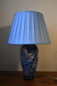 A contemporary baluster form table lamp decorated in bird and flower decoration with pale blue
