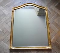 A gilt framed wall mirror with arched bevelled plate. H.90 W.70cm