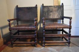 A pair of 19th century oak throne chairs with lion mask finials and leather seats and backs on