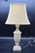 A carved alabaster urn design table lamp with cream shade. H.39 (H.56cm with shade) W.34cm