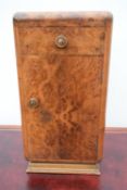 An Art Deco burr walnut bedside cabinet.