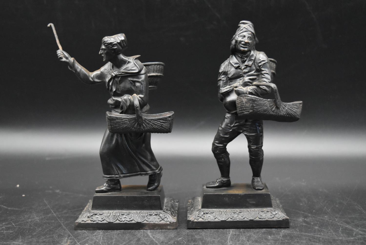 A pair of 20th century black basalt 'Farmer and Farmers Wife' figures, standing on square bases. H.