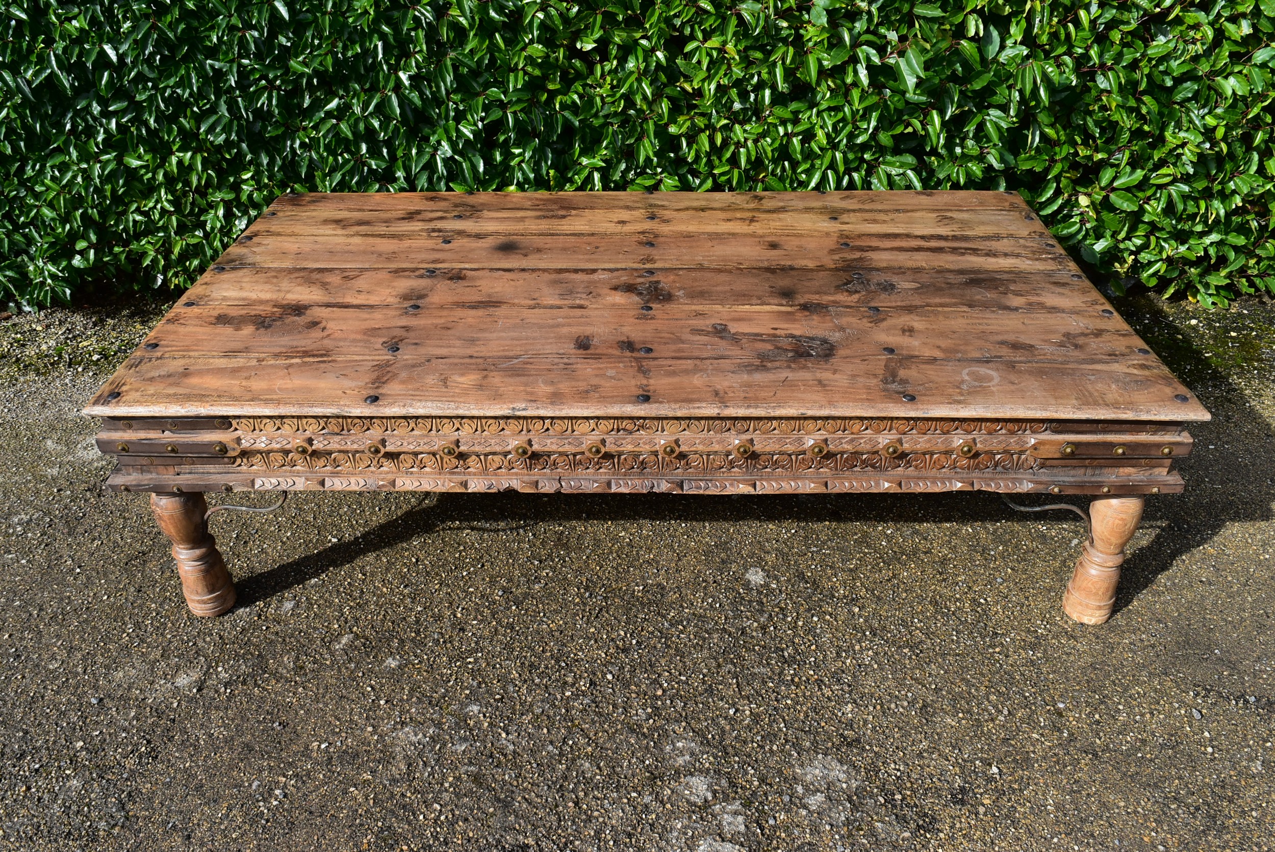 A large Indian teak carved and metal bound low table. - Image 2 of 8