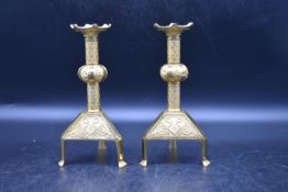 A pair of 20th century brass candlesticks, decorated with inlaid foliate and crisscross design to