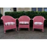 A set of three Lloyd Loom vintage woven conservatory armchairs with fitted upholstered and sprung