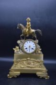 A late 19th century French gilt metal mantle clock with a white dial, decorated with a Napoleon