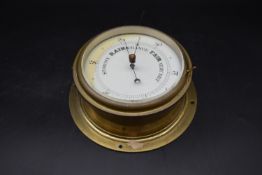 A 19th century brass rivet style Aneroid Barometer with a white enamel dial. H.24 W.24 D.12cm