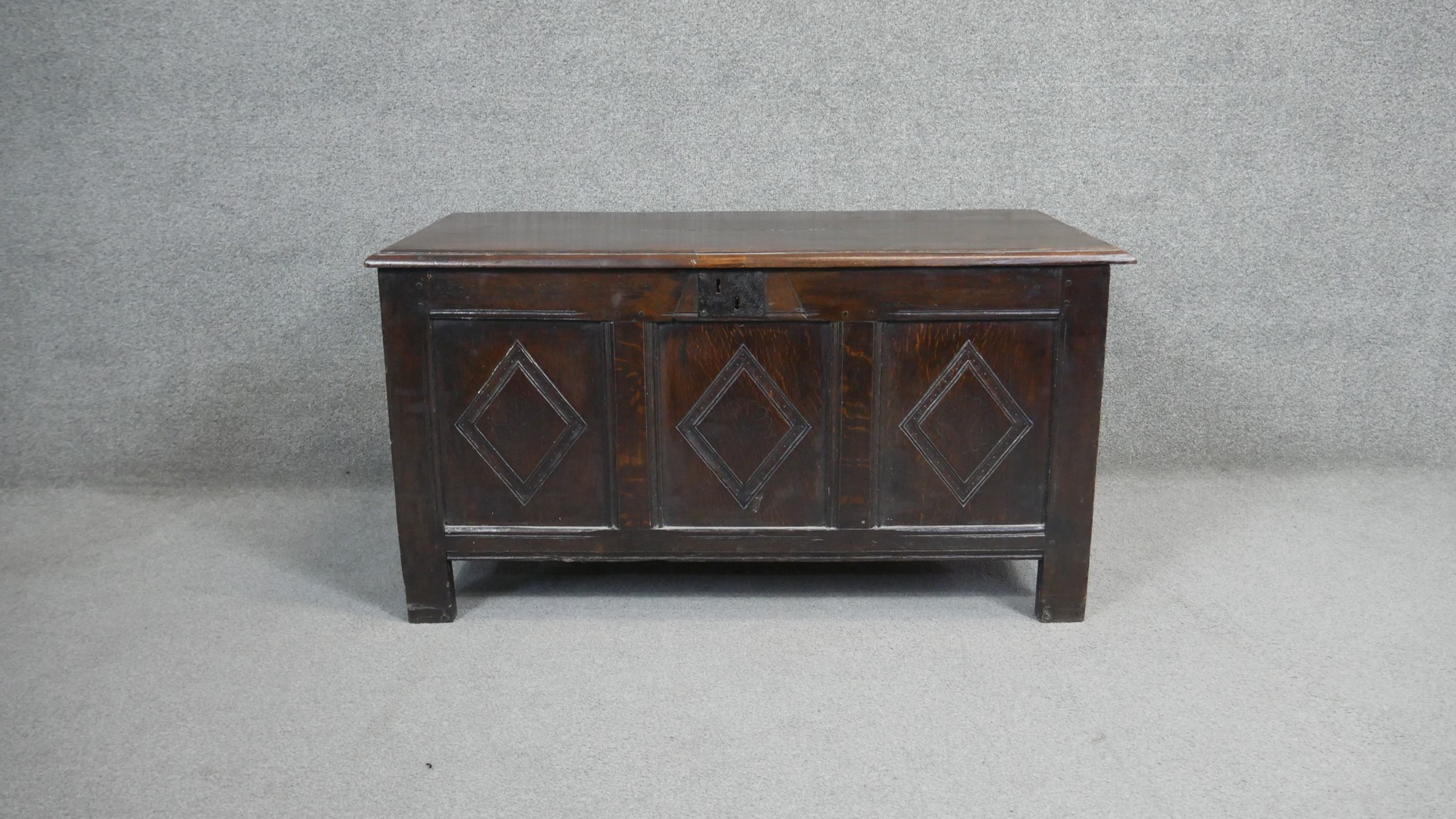 A 17th century oak coffer with lozenge carved panels raised on stile supports. H.54 W.104 D.49cm - Image 2 of 11