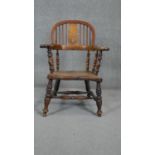 A 19th century fruitwood Windsor armchair with elm seat on turned stretchered supports. (Lower splat