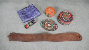 An embroidered silk textile along with a leather belt and tribal straw coasters and place mats. L.67