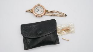 A leather cased 9 carat rose gold vintage ladies wrist watch with gold plated sprung bracelet and
