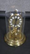A contemporary gilt and brass anniversary clock with perspex display dome. H.32CM