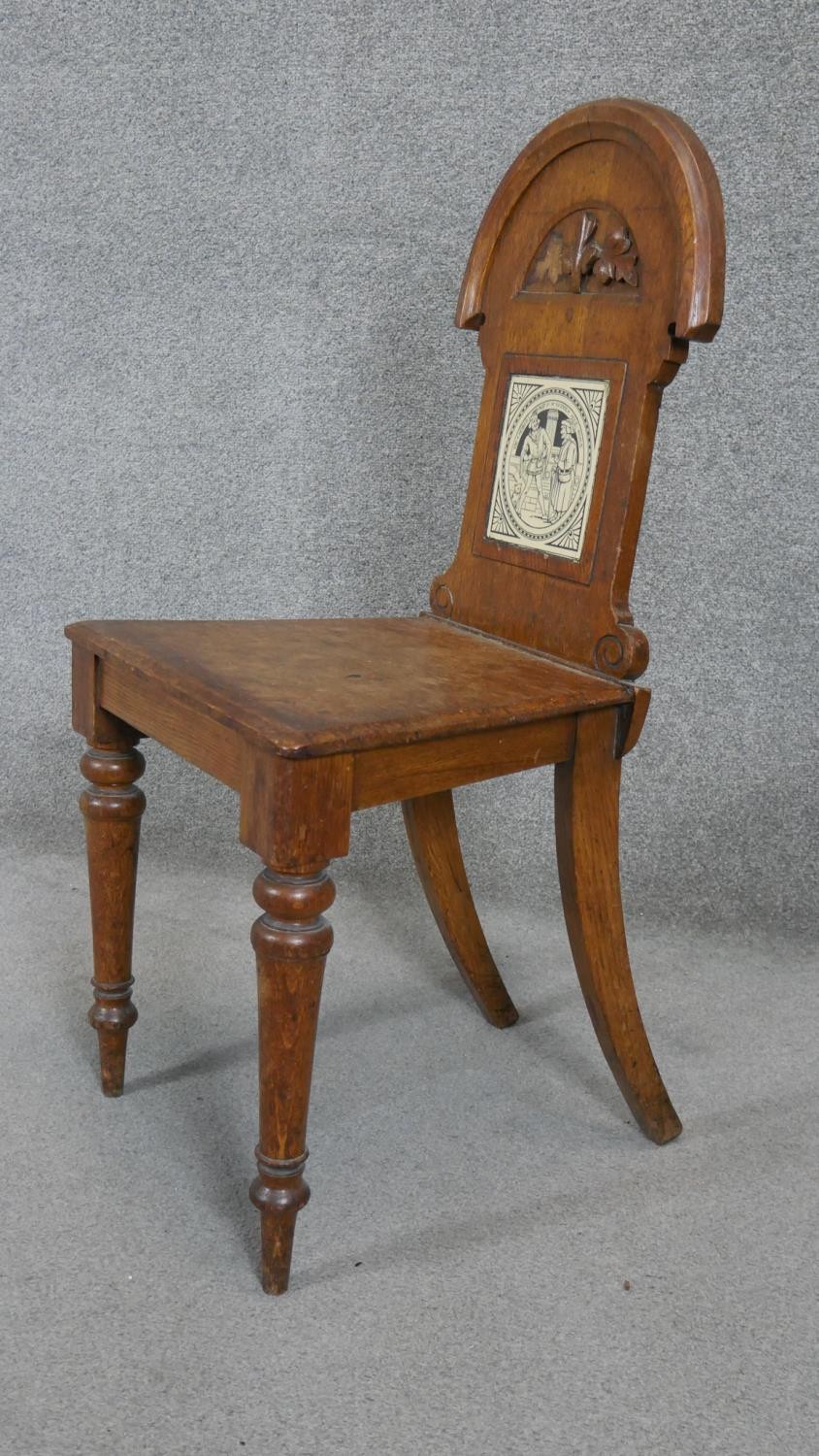 A late 19th century oak hall chair with inset Mintons tile to the back above panel seat on turned - Image 5 of 7