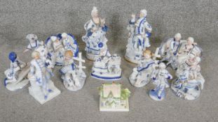 A collection of 12 blue and white gilded porcelain figures. Including a Coalport miniature cottage