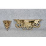 Two giltwood shelves. One Victorian with a carved figural figure and foliate motifs. L.30 W.73 D.