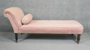 A Victorian chair back chaise longue in candy striped upholstery on turned mahogany tapering