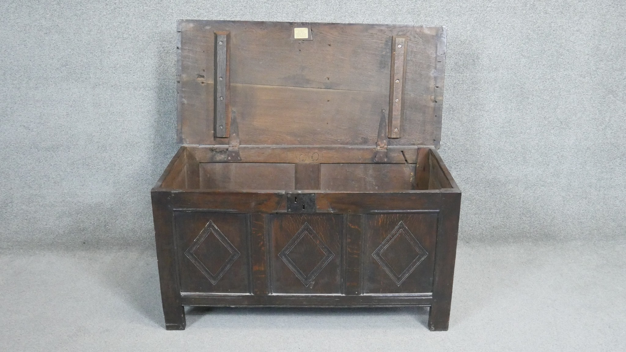 A 17th century oak coffer with lozenge carved panels raised on stile supports. H.54 W.104 D.49cm - Image 4 of 11