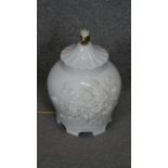 A white glazed ceramic relief floral design table lamp. H.35CM