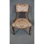 A Victorian carved walnut nursing chair on cabriole supports.
