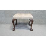 A Georgian style mahogany stool in striped floral upholstery with shell carved ball and claw